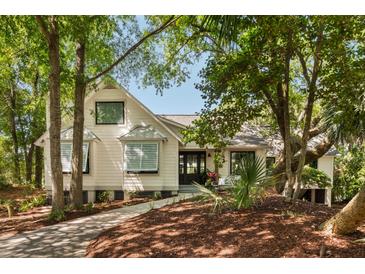 Charming two-story home with a beautifully landscaped front yard and mature trees for added privacy at 15 Edgewater Aly, Isle of Palms, SC 29451