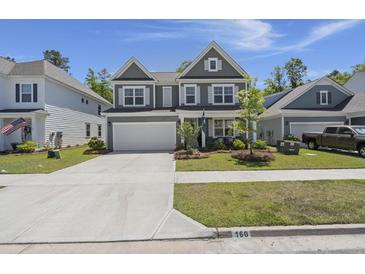 Charming two-story home with a manicured lawn, a two-car garage, and attractive landscaping at 160 Cherry Grove Dr, Summerville, SC 29483