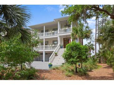 Charming two-story home with double balconies, landscaped yard, and stairway leading to the entrance at 1801 Landfall Way, Seabrook Island, SC 29455