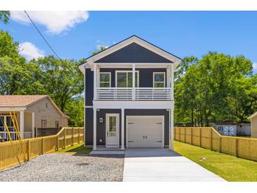 Two-story home featuring a modern design with a white garage door and trim, plus a second-story balcony at 1917 Jason St, North Charleston, SC 29406