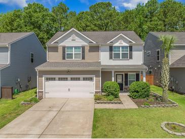 Charming two-story home with a two-car garage, manicured lawn, and delightful landscaping at 259 Weeping Cypress Dr, Moncks Corner, SC 29461