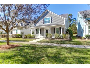 Charming gray two-story home with a inviting front porch and well-maintained lawn on a bright day at 2909 Swamp Sparrow Cir, Johns Island, SC 29455