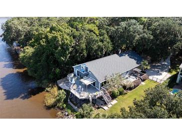 Stunning elevated coastal home with a deck, manicured lawn, and lush surrounding landscape at 4940 Lambs Road Rd, North Charleston, SC 29418