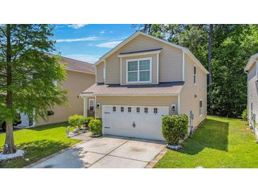 Charming two-story home with a well-maintained lawn and a two car garage at 9759 Seed St, Ladson, SC 29456