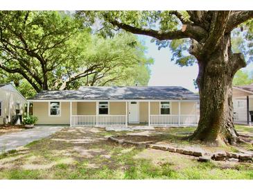 Charming single-story home featuring a covered front porch and mature shade trees in a tranquil setting at 1232 Hawthorne Cir, Hanahan, SC 29410