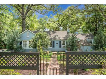 Charming single-story home with a brick pathway, lush landscaping, and a decorative black metal fence at 1316 Wichman St, Walterboro, SC 29488