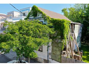 Exterior view of a weathered house with vines and trees at 20 Felix St, Charleston, SC 29403