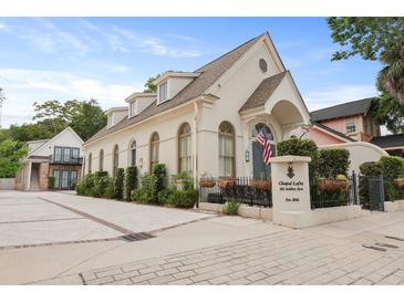 Elegant building featuring a white facade, arched windows, and manicured landscaping at 221 Ashley Ave # Abc, Charleston, SC 29403