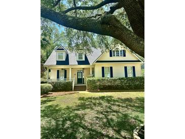 Charming home with tidy landscaping, green lawn, and a delightful covered porch at 23 Forde Row, Charleston, SC 29412