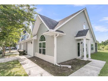 Light gray townhouse featuring a charming architectural design with a covered entrance and an arched window detail at 281 Jackson St, Goose Creek, SC 29445
