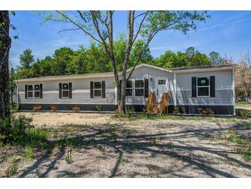 Single-story home boasts gray siding, black shutters, and a well-manicured front yard at 317 Marion Rd, Dorchester, SC 29437