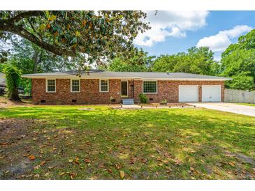 Charming brick home with a well-manicured lawn and attached two-car garage at 5823 Lakeview Dr, Hanahan, SC 29410