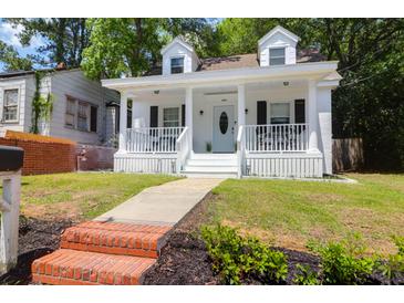 Charming white two-story home with a inviting front porch and landscaped yard at 1920 Iris St, North Charleston, SC 29405