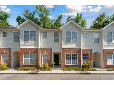 Charming townhouse featuring a brick facade, well-manicured landscaping, and multiple windows at 241 Howle Ave # F, Charleston, SC 29412
