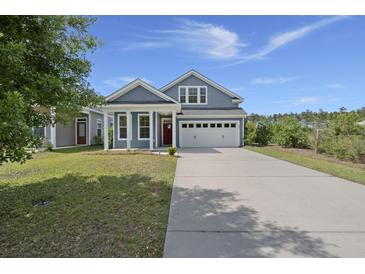 Charming blue two-story home with a well-manicured lawn and a two-car garage at 267 Palmetto Walk Dr, Summerville, SC 29486