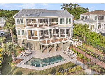Stunning three-story home with private pool, outdoor lounge, and picturesque fenced-in yard at 3128 Palmetto Blvd, Edisto Island, SC 29438