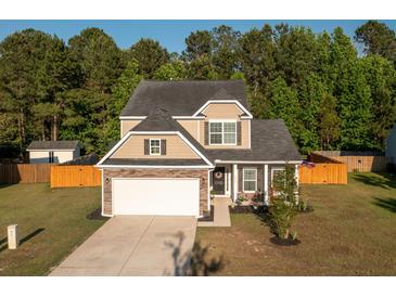 Charming two-story home with stone accents, well-kept lawn, and an attached two car garage at 8035 Mckayla Rd, Summerville, SC 29483