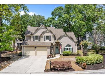 Charming two-story home featuring a two-car garage, manicured lawn, and inviting front entrance with a blue door at 1337 Horseshoe Bnd, Mount Pleasant, SC 29464