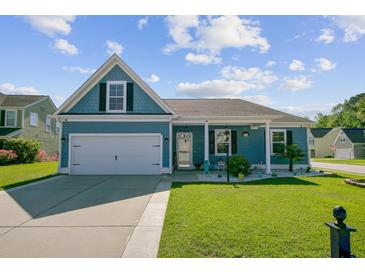 Charming blue home with a well-manicured lawn and a two-car garage on a sunny day at 3801 Canary Ct, North Charleston, SC 29420