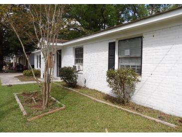 Charming single-story home with white brick exterior and well-maintained lawn at 409 Robin Dr, Goose Creek, SC 29445