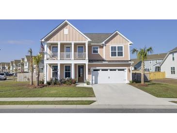Charming two-story home featuring a welcoming front porch, two car garage and freshly manicured lawn at 661 Black Pine Rd, Moncks Corner, SC 29461