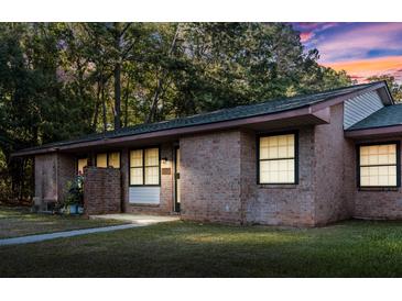 Charming single-story brick home featuring a well-maintained lawn and beautiful landscaping at 7914 Dutch Ct, North Charleston, SC 29420