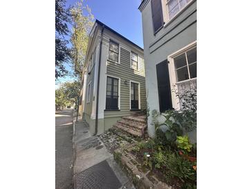 Charming two-story home featuring a well-maintained exterior and brick stairs leading to the entrance at 9 West St # 1, Charleston, SC 29401