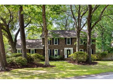 Traditional brick home with black shutters and mature trees in a lush green front yard at 108 Old Dominion Dr, North Charleston, SC 29418