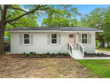 Charming brick home with white trim, a pink door, and a neatly landscaped front yard at 1109 Hillside Dr, Charleston, SC 29407