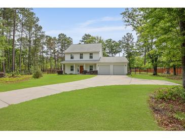Charming two-story home with a well-manicured lawn and a long driveway leading to a two-car garage at 1502 Southwick Dr, Johns Island, SC 29455