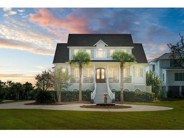 Stately two-story white home with palm trees, grand staircase, fountain, and a beautifully landscaped circular driveway at 1531 Murphys Island Ct, Awendaw, SC 29429