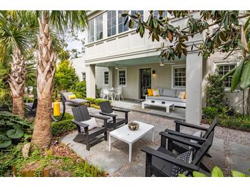 Beautiful outdoor patio with stylish furniture, a relaxing lounge chair, and a covered seating area for entertaining at 21 1/2 Pitt St, Charleston, SC 29401