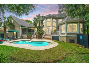 Private backyard pool featuring lush landscaping and architectural details, perfect for relaxation at 225 River Oak Dr, Mount Pleasant, SC 29464