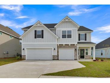 Charming two-story home features a two-car garage and inviting front porch with stylish architectural details at 3307 Sawlog Dr, Summerville, SC 29486