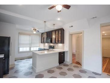 Bright kitchen with white countertops, tile floors, stainless appliances, and dark cabinetry at 35 Society # H, Charleston, SC 29401