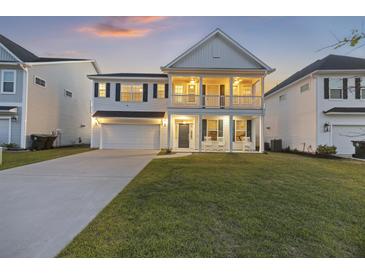 Charming two-story home with double porches, lush lawn, and a welcoming facade at sunset at 555 Dunswell Dr, Summerville, SC 29486