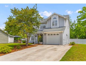Charming two-story home with a well-manicured lawn and a one-car garage at 828 Williamsburg Ln, Charleston, SC 29414