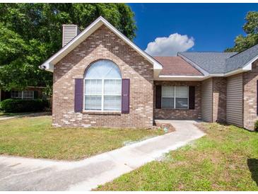 Charming brick home with a well-manicured lawn and inviting walkway leading to the front door at 9630 N Cardinal Dr, Ladson, SC 29456