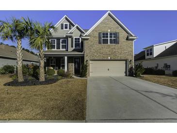 Attractive two-story home with brick and siding, palm trees, and a well-manicured lawn at 1209 Hammrick Ln, Johns Island, SC 29455