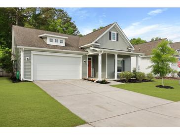 Charming single-Gathering home featuring a two-car garage, gray siding, orange door, and well-maintained landscaping at 1221 Lois Allen Rd, Johns Island, SC 29455