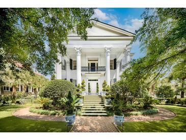 Stately white home with a grand entrance and lush landscaping, creating a picturesque curb appeal at 172 Tradd St, Charleston, SC 29401