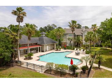 A serene community pool area with palm trees, lounge chairs, and umbrellas offers a relaxing outdoor experience at 188 Midland Parkway # 110, Summerville, SC 29485