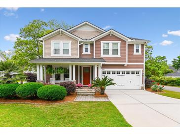 Beautiful two-story home featuring well-manicured lawn, red door, and attached two-car garage at 2017 Woodland Shores Rd, Charleston, SC 29412