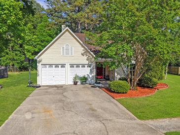 Charming one-story home with a two-car garage, mature trees, and a well-manicured lawn at 206 Challis Ct, Goose Creek, SC 29445