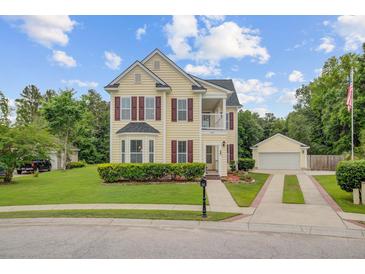 Charming two-story home with a detached garage, red shutters, and a manicured front yard at 249 Old Savannah Dr, Goose Creek, SC 29445