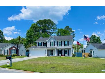 Traditional two-story home featuring a manicured lawn, attached garage, and charming curb appeal under a blue sky at 302 Axeminster Ct, Goose Creek, SC 29445