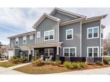 Charming gray two-story home with covered porch and rocking chairs offering curb appeal at 305 Flowering Peach Ct # 202, Charleston, SC 29414