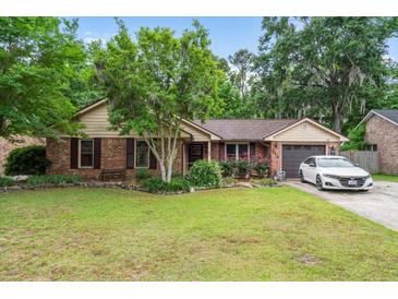 Charming brick home with lush lawn, blooming flowerbeds and a single car garage at 313 Houston Dr, Ladson, SC 29456