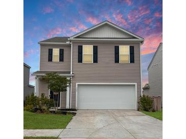 Charming two-story home with a two car garage, beautiful siding, and a well manicured lawn at 323 Bear Paw Ln, Summerville, SC 29486