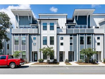 Contemporary townhome exterior featuring modern design and neutral color palette with a vibrant red pickup truck at 4585 Summey St, North Charleston, SC 29405